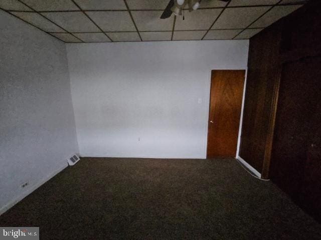 unfurnished room with carpet floors, a paneled ceiling, and ceiling fan