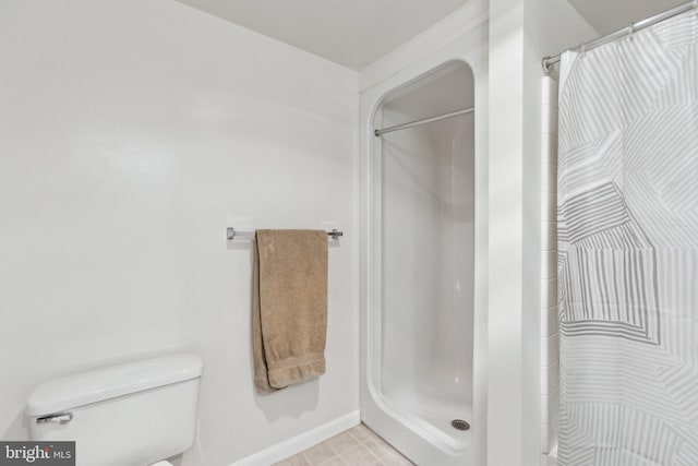 bathroom featuring curtained shower and toilet