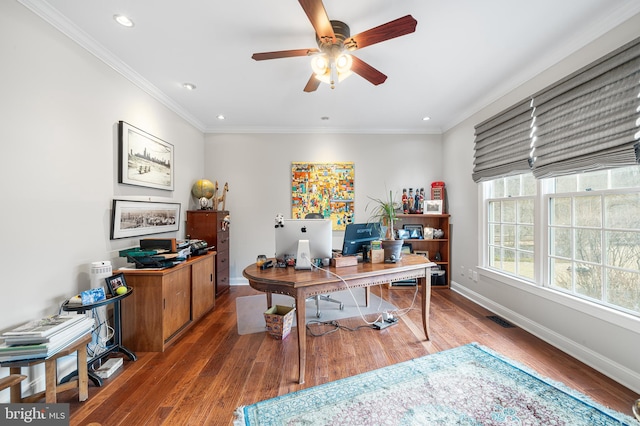 office featuring baseboards, visible vents, a ceiling fan, ornamental molding, and wood finished floors