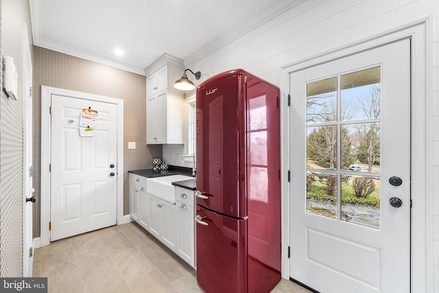 doorway with ornamental molding, a sink, and baseboards