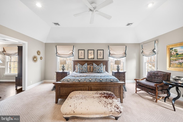 carpeted bedroom with a tray ceiling, visible vents, vaulted ceiling, and baseboards