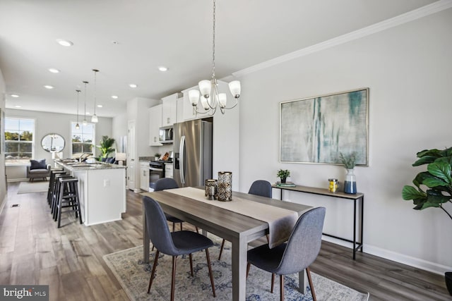 dining space with wood-type flooring and crown molding