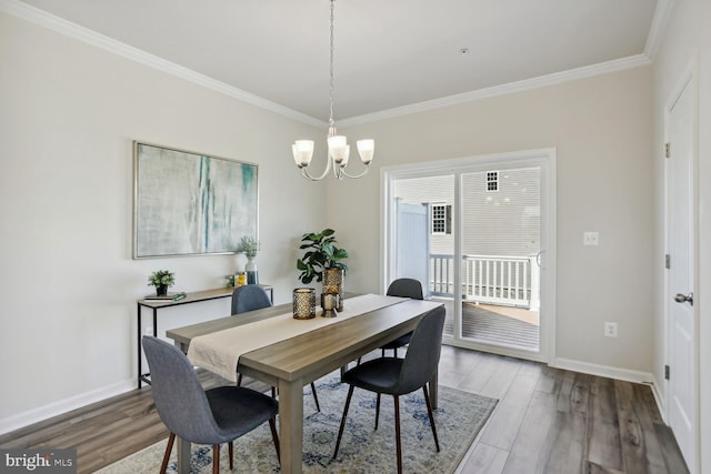 dining room with an inviting chandelier, hardwood / wood-style flooring, and ornamental molding