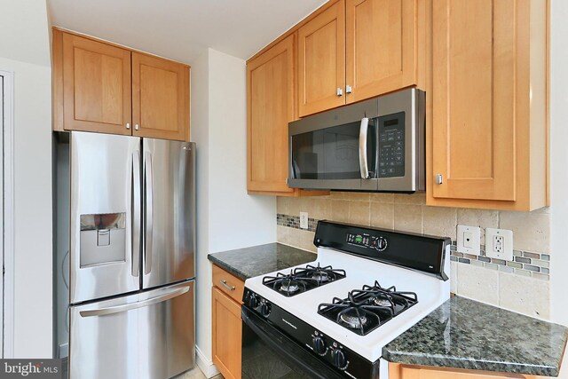 kitchen featuring dark stone counters, tasteful backsplash, and stainless steel appliances