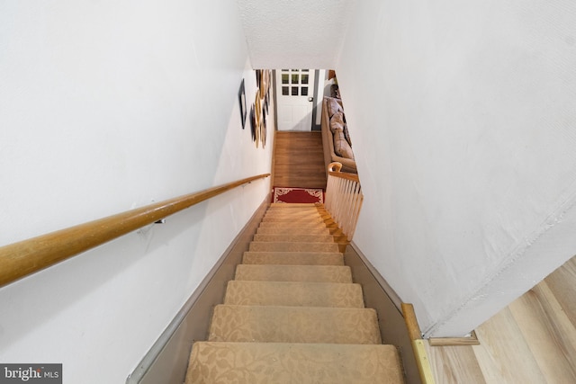 stairway with a textured ceiling