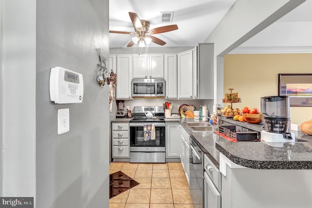 kitchen with sink, crown molding, light tile patterned floors, ceiling fan, and appliances with stainless steel finishes