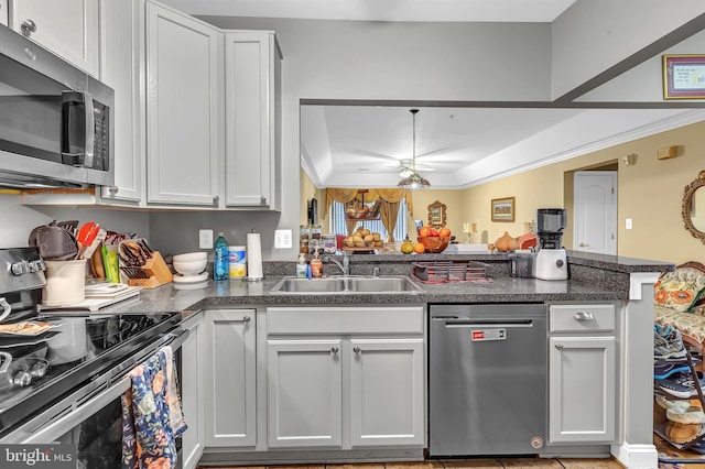 kitchen with sink, stainless steel appliances, ornamental molding, white cabinets, and kitchen peninsula