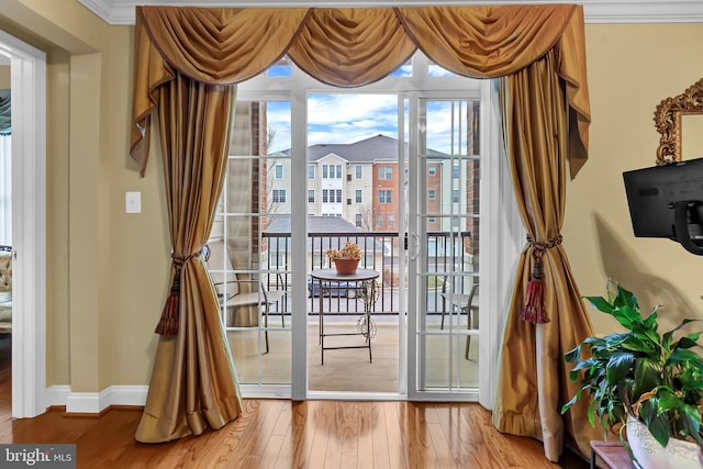 doorway to outside with crown molding and wood-type flooring