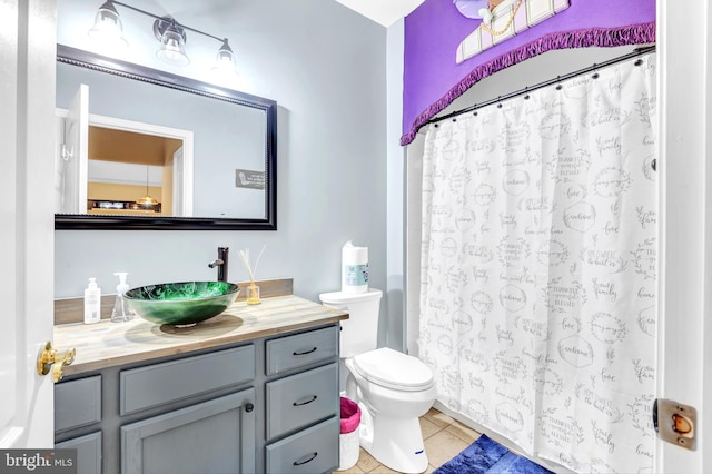 bathroom with tile patterned flooring, vanity, a shower with curtain, and toilet