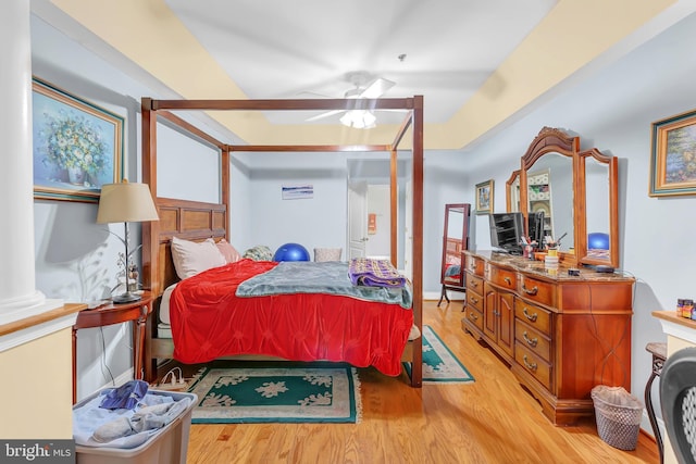 bedroom with decorative columns and light wood-type flooring