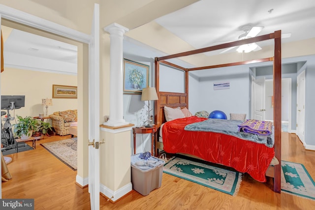 bedroom featuring hardwood / wood-style flooring, ceiling fan, and ornate columns