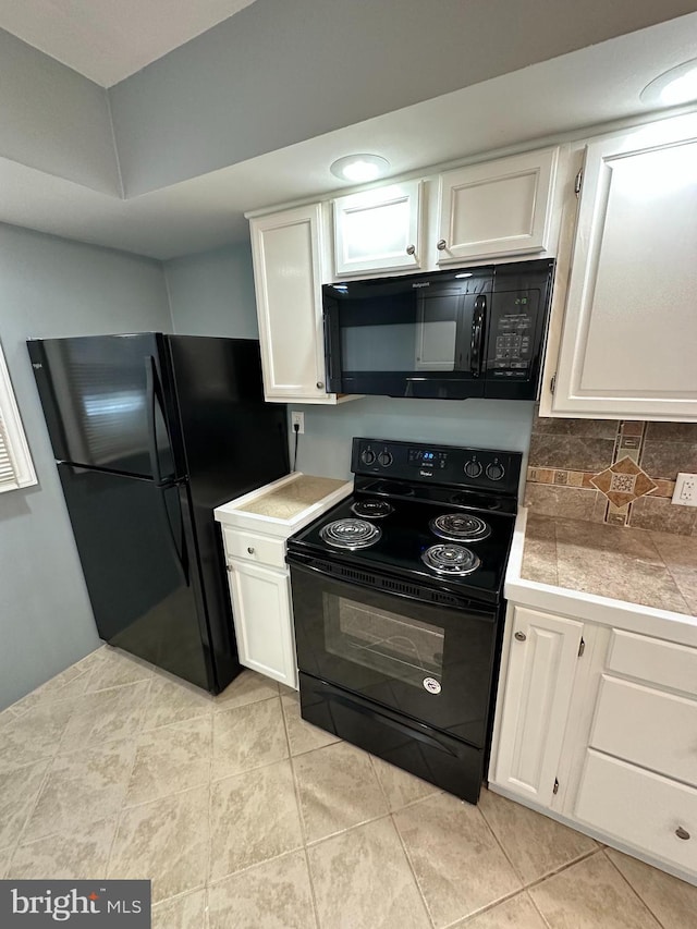 kitchen featuring white cabinetry, backsplash, light tile patterned floors, and black appliances