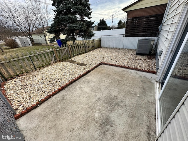 view of yard featuring central AC, a storage unit, and a patio area