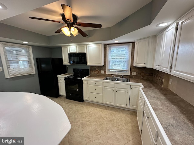 kitchen with tasteful backsplash, white cabinetry, sink, and black appliances