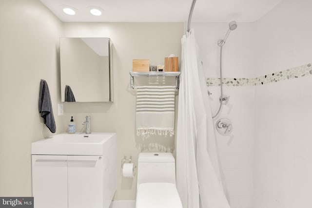 full bath featuring toilet, a tile shower, and vanity