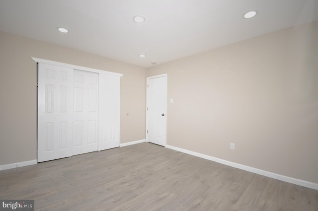 unfurnished bedroom featuring light wood-type flooring and a closet