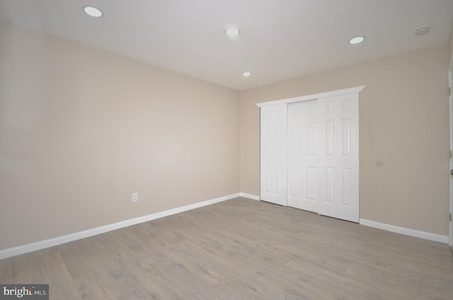 unfurnished bedroom with light hardwood / wood-style floors and a closet