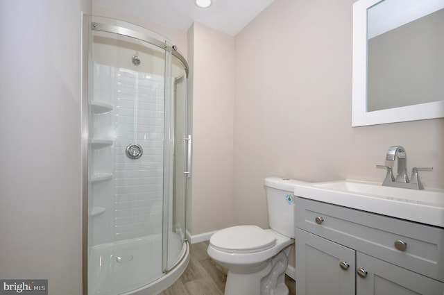 bathroom featuring an enclosed shower, vanity, hardwood / wood-style flooring, and toilet