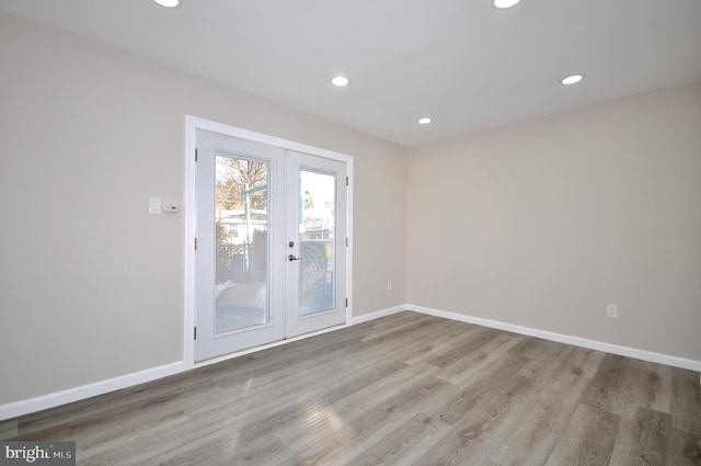 unfurnished room with french doors and light hardwood / wood-style floors