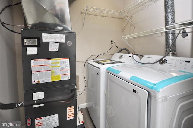 clothes washing area featuring separate washer and dryer and heating unit