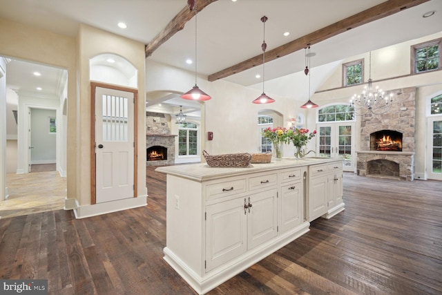 kitchen featuring open floor plan, white cabinetry, a stone fireplace, and dark wood-style flooring