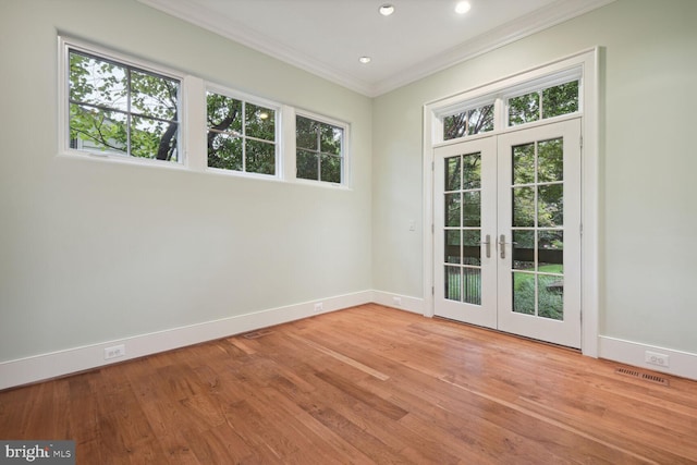 doorway to outside with wood finished floors, a healthy amount of sunlight, baseboards, ornamental molding, and french doors