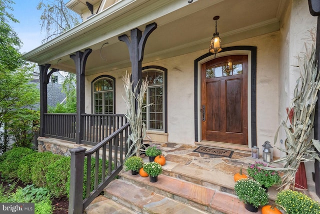 property entrance featuring covered porch and stucco siding