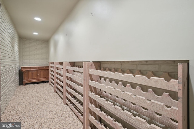 hall with brick wall, carpet flooring, and recessed lighting