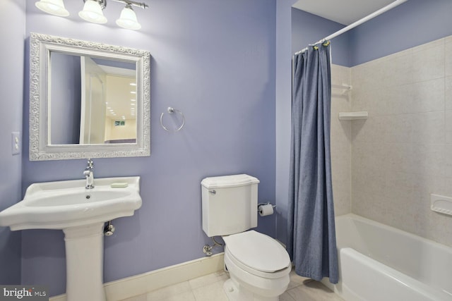 bathroom with tile patterned flooring, toilet, shower / tub combo, a sink, and baseboards