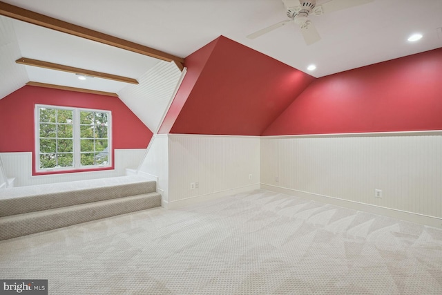 additional living space featuring vaulted ceiling with beams, carpet, a ceiling fan, and wainscoting