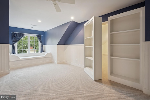 additional living space with visible vents, a wainscoted wall, carpet flooring, built in shelves, and recessed lighting