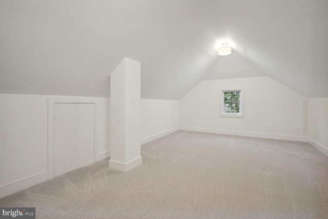 additional living space featuring carpet flooring, vaulted ceiling, and baseboards