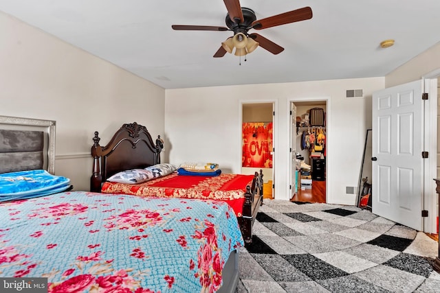 bedroom featuring connected bathroom, a walk in closet, a closet, and ceiling fan