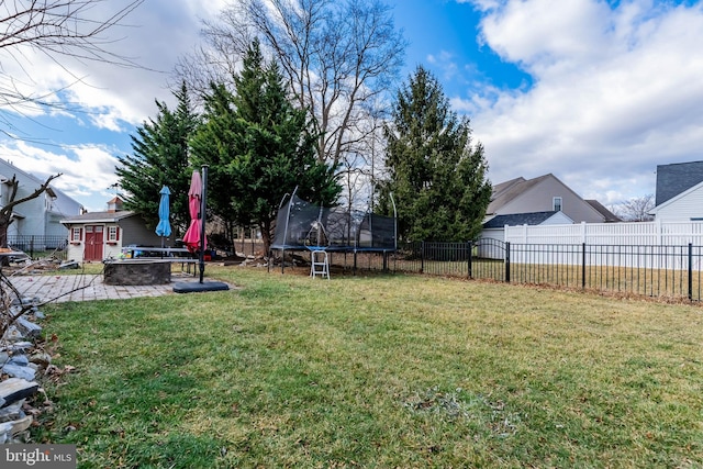 view of yard featuring a patio area, a trampoline, and a storage shed