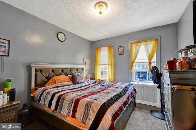 bedroom featuring vaulted ceiling, light carpet, and a textured ceiling