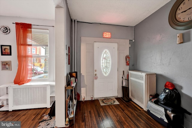 entrance foyer with radiator, a textured ceiling, and dark hardwood / wood-style floors