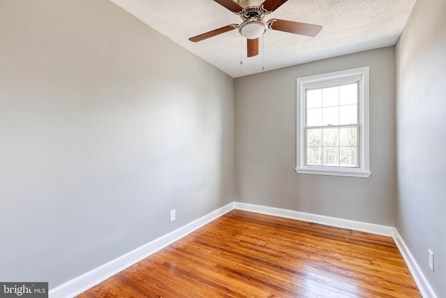 spare room with ceiling fan, light hardwood / wood-style flooring, and a textured ceiling