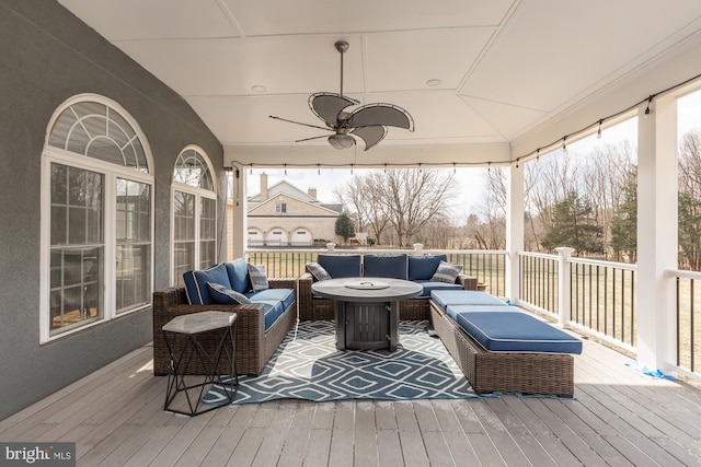 wooden deck featuring outdoor lounge area and ceiling fan