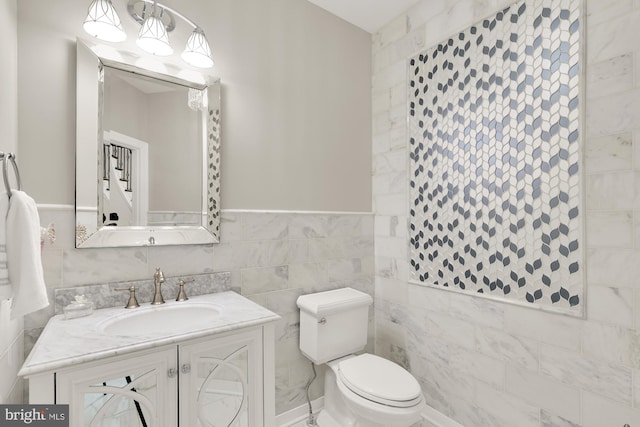 bathroom featuring toilet, tile walls, and vanity