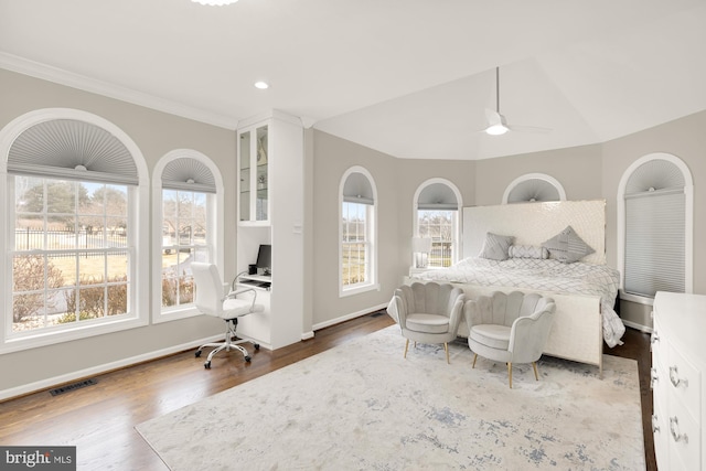 bedroom featuring lofted ceiling, wood finished floors, visible vents, and baseboards