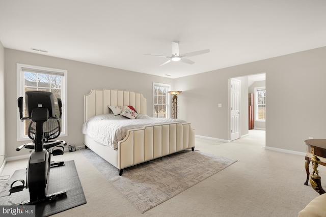 bedroom with baseboards, ceiling fan, visible vents, and light colored carpet