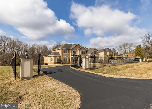 view of front facade featuring a fenced front yard, a residential view, a gate, and a front lawn