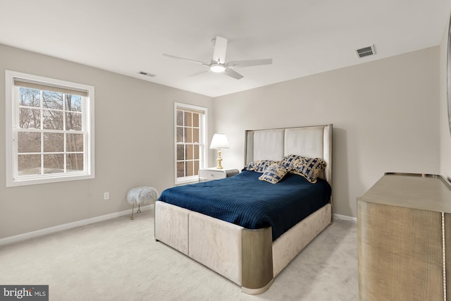 bedroom with visible vents, light carpet, and baseboards