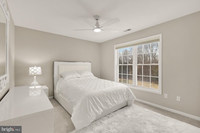 bedroom with baseboards, visible vents, a ceiling fan, and light colored carpet