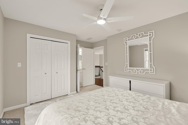 bedroom featuring a ceiling fan, baseboards, a closet, and light colored carpet