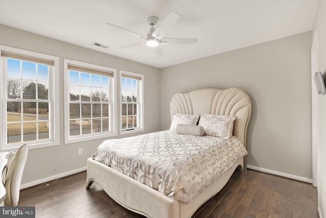 bedroom featuring dark wood-style floors, a ceiling fan, visible vents, and baseboards