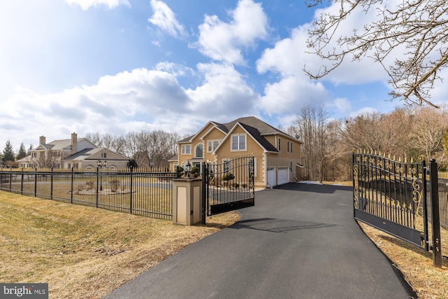 view of street with aphalt driveway, a gate, and a gated entry