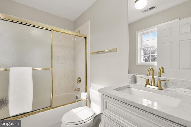 bathroom featuring toilet, enclosed tub / shower combo, visible vents, and vanity