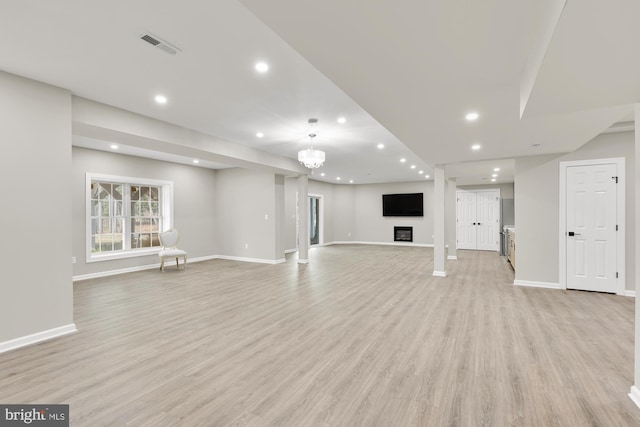 unfurnished living room with baseboards, light wood-type flooring, visible vents, and recessed lighting