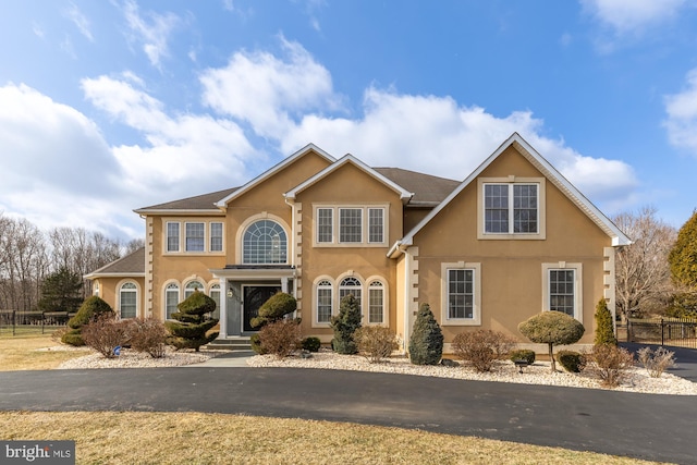 view of front of home featuring fence and stucco siding